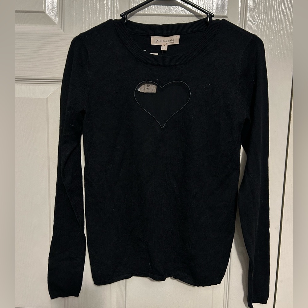 Black sweater with heart cut out.
